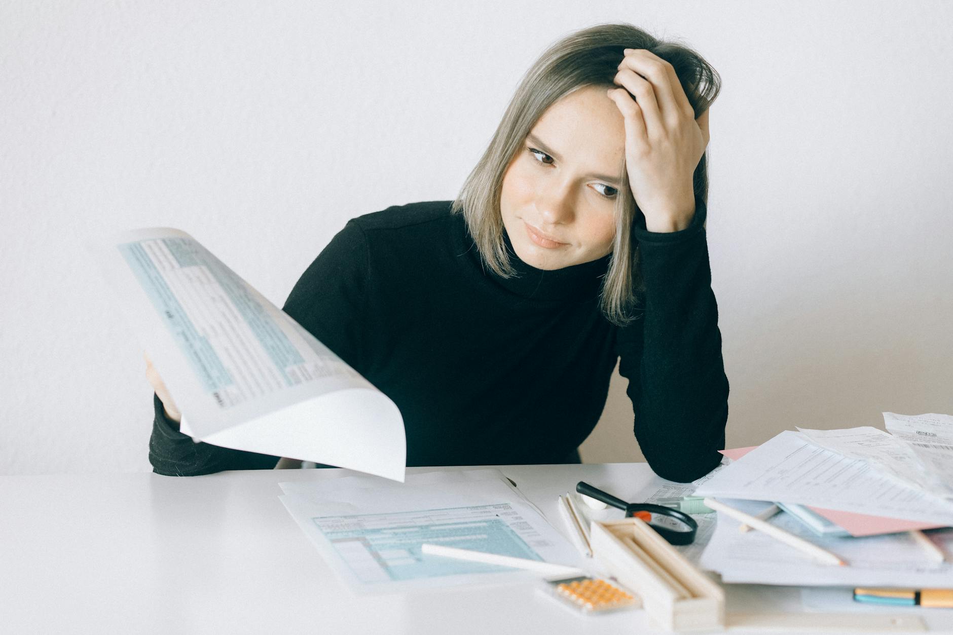 woman in black long sleeves holding white paper